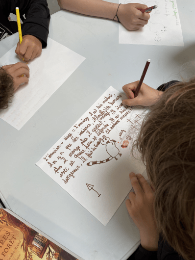 Zoom sur un enfant écrivant pendant l'atelier