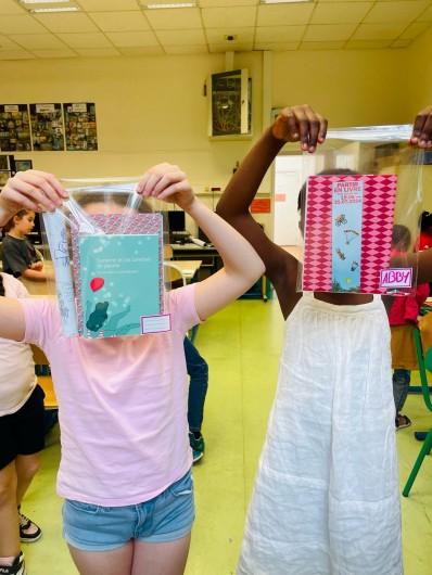 Enfants de l'atelier avec leur pochette de création : livre de l'autrice, carnet, marque-page