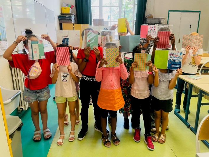 Groupe des enfants de la résience avec leur pochette de création : livre de l'autrice, carnet, marque-page